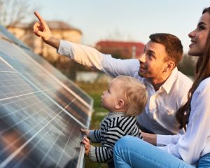 Mann und Frau mit Baby vor Photovoltaik